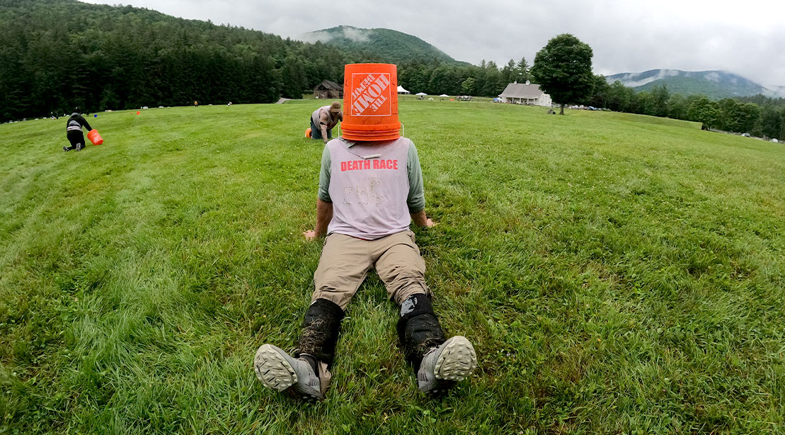 2024 Death Race competitor taking a break with a home depot 5 gallon bucket on his head