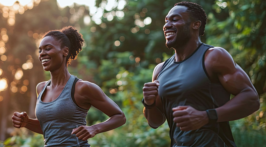 Black couple running outdoors as part of their outdoor workouts