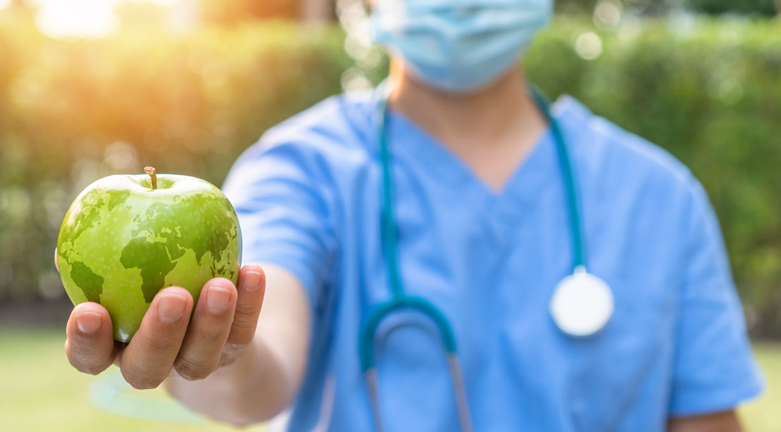 Doctor holding an apple with the continents imposed on it