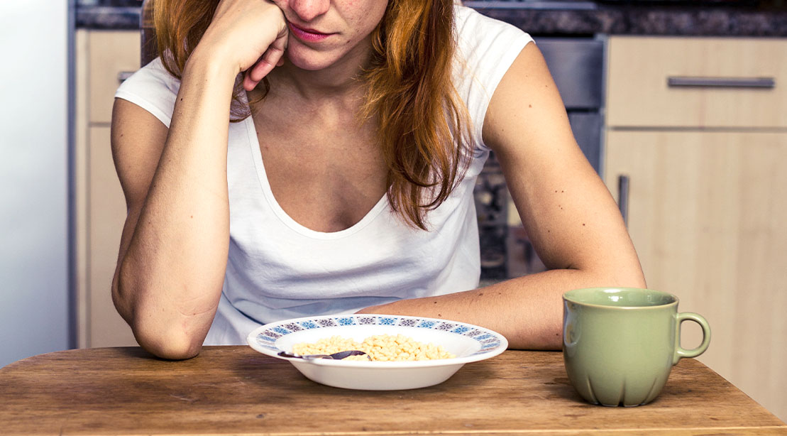 Female staring at her breakfast and not wanting to practice fasting