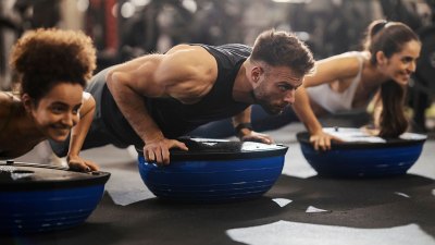 Fit Young Muscular man working out in a fitness class using bosu ball exercises