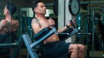 Muscular fit man with tattoos working out his abs with a captain's chair exercise and workout