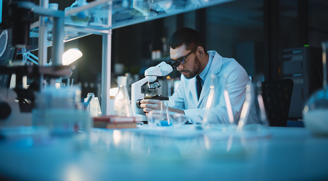 Scientist looking at fat cells under a microscope