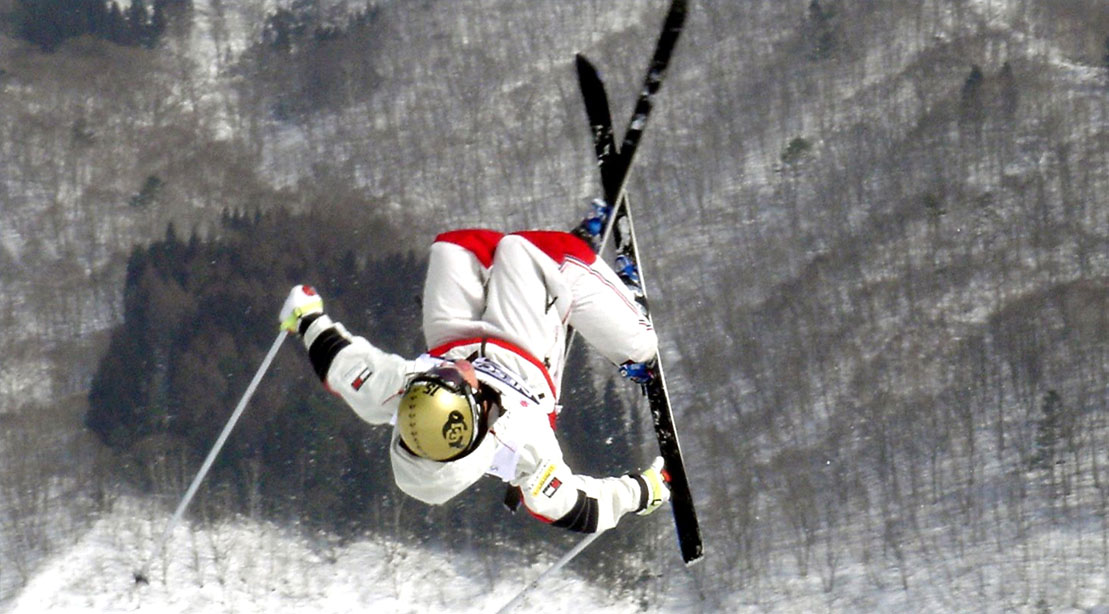 Skiier Jeremy Bloom performing a high flying trick on his skiis at the Winter Olympics