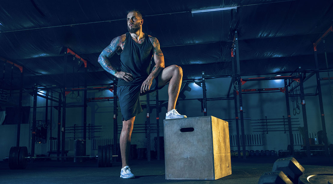 Tall fit man working out with the single leg box squat exercise to build his lower body muscles and leg muscles