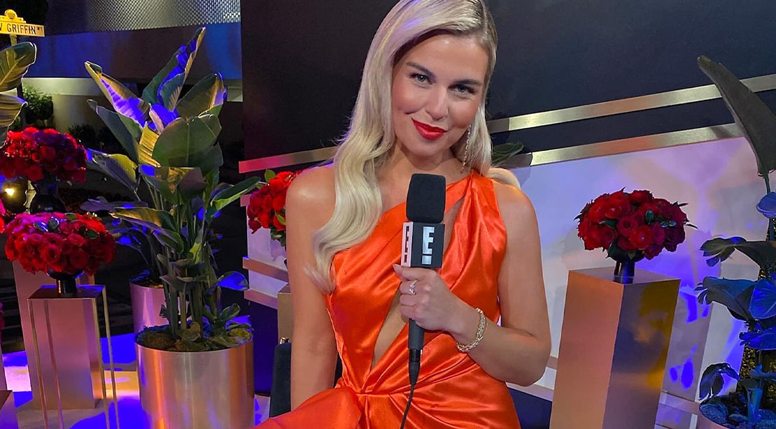 Tanya Rad holding an E! microphone at an event